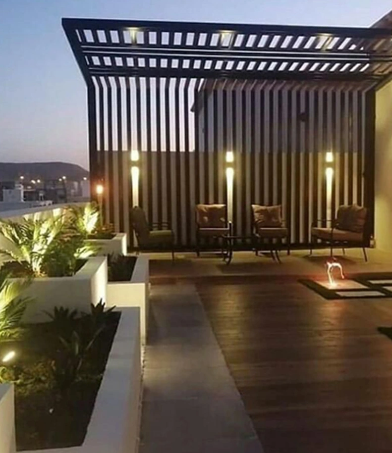 An outdoor slatted shade structure, with an open overhead pattern and coordinated vertical side panels.